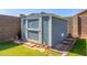A light-blue shed sits on a small strip of yard bordered by block fencing and brick pavers at 18008 W Tina Ln, Surprise, AZ 85387