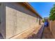 Side yard view with brick path leading to backyard with blue garbage bins and block wall at 18008 W Tina Ln, Surprise, AZ 85387