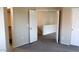 Neutral-toned bedroom with carpet, white doors, and an open doorway to another room at 1961 N Hartford St # 1109, Chandler, AZ 85225