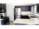 A modern kitchen with stainless steel appliances, granite countertops, and stylish dark blue cabinets at 1961 N Hartford St # 1109, Chandler, AZ 85225