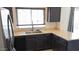 A well-lit kitchen featuring stainless steel appliances, dark cabinets, and a stainless steel sink at 1961 N Hartford St # 1109, Chandler, AZ 85225