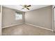 Empty bedroom showcasing neutral walls, tile flooring, ceiling fan and a window at 2094 N Sweetwater Dr, Casa Grande, AZ 85122