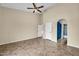 Spacious bedroom featuring tile floors, a ceiling fan, and two closets with potential access to a bathroom at 2094 N Sweetwater Dr, Casa Grande, AZ 85122