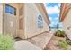 Side exterior view with stucco, decorative windows, and landscaping leading to the waterfront at 2094 N Sweetwater Dr, Casa Grande, AZ 85122