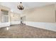 Spacious living room with wainscotting, high ceilings, decorative chandeliers, and ceramic tile flooring at 2094 N Sweetwater Dr, Casa Grande, AZ 85122