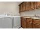 Laundry room featuring a sink, wood cabinets, granite countertop, and a washer and dryer at 2111 N Piper Pl, Mesa, AZ 85215