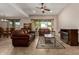 Inviting living room featuring leather sofas, a ceiling fan, and a cozy fireplace at 2111 N Piper Pl, Mesa, AZ 85215