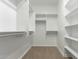 Bright walk-in closet with white shelving, hanging bars, and carpet flooring at 2111 N Piper Pl, Mesa, AZ 85215