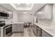 Contemporary kitchen and dining area with stainless steel appliances, light cabinets, and wood-look flooring at 2524 W Kiva Ave, Mesa, AZ 85202
