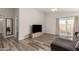 Spacious living room features updated wood look flooring, a ceiling fan, and a sliding glass door at 2524 W Kiva Ave, Mesa, AZ 85202
