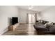Spacious living room features updated wood look flooring, a ceiling fan, and a sliding glass door at 2524 W Kiva Ave, Mesa, AZ 85202
