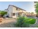Expansive backyard with gravel landscaping, green artificial grass, and a view of the home's exterior at 2754 E Michelle Way, Gilbert, AZ 85234