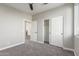 A carpeted bedroom with a ceiling fan, white walls, and closet at 2754 E Michelle Way, Gilbert, AZ 85234