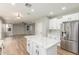 A kitchen with an island with quartz countertop, stainless steel appliances, and opens into the living room at 2754 E Michelle Way, Gilbert, AZ 85234