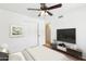Well-lit bedroom featuring a ceiling fan, closet, and a television on a stand at 3228 W Mercer Ln, Phoenix, AZ 85029