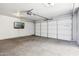 Clean garage with white door, mounted TV, and garage door opener at 3228 W Mercer Ln, Phoenix, AZ 85029