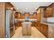 Bright eat-in kitchen showcasing an island, stainless steel appliances, and wood cabinetry at 3228 W Mercer Ln, Phoenix, AZ 85029