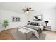 Well-lit bedroom showcasing a ceiling fan, neutral color palette and stylish decor at 3228 W Mercer Ln, Phoenix, AZ 85029
