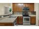 Well-lit kitchen featuring stainless steel appliances, tile backsplash, and wooden cabinetry at 3330 S Gilbert Rd # 1020, Chandler, AZ 85286