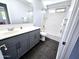 This renovated bathroom showcases modern tile work, grey vanity, and bright mirror at 3330 W Gran Paradiso Dr, Phoenix, AZ 85086
