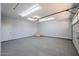 Clean garage with speckled epoxy floor, overhead lighting, and a white garage door at 3330 W Gran Paradiso Dr, Phoenix, AZ 85086