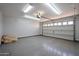Spacious garage featuring overhead lighting, epoxy floor, and a white garage door at 3330 W Gran Paradiso Dr, Phoenix, AZ 85086