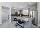 This kitchen features gray cabinets, granite countertops, a stainless steel refrigerator, and a kitchen island with seating at 3330 W Gran Paradiso Dr, Phoenix, AZ 85086