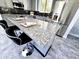 Kitchen island with seating, granite countertop, stainless steel refrigerator, gray cabinets, and backsplash at 3330 W Gran Paradiso Dr, Phoenix, AZ 85086