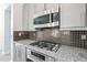 Modern kitchen with granite countertops, gas cooktop, and stainless steel microwave at 3330 W Gran Paradiso Dr, Phoenix, AZ 85086