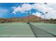 Exterior shot of tennis courts surrounded by desert, mountains and cloudy blue skies at 3330 W Gran Paradiso Dr, Phoenix, AZ 85086