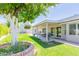 Charming backyard featuring a lush lawn, brick planter, and covered patio, creating a relaxing outdoor retreat at 3544 E Fox St, Mesa, AZ 85213