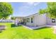 Beautiful backyard with green grass, a covered patio, and mature landscaping, perfect for Gathering enjoyment at 3544 E Fox St, Mesa, AZ 85213