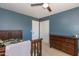 Spacious bedroom with a ceiling fan, closet, and a wooden dresser for storage at 3544 E Fox St, Mesa, AZ 85213