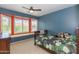 Cozy bedroom features a ceiling fan, and a window seat with plantation shutters for natural light at 3544 E Fox St, Mesa, AZ 85213