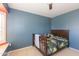 Comfortable bedroom featuring a ceiling fan and a large window with shutters for natural light at 3544 E Fox St, Mesa, AZ 85213