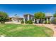 Beautifully landscaped front yard with lush green grass, mature trees, and attractive desert landscaping at 3544 E Fox St, Mesa, AZ 85213