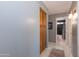 Hallway leads to a bathroom, featuring wood cabinets for storage, and tile flooring at 3544 E Fox St, Mesa, AZ 85213