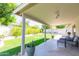 Covered patio with comfortable seating and a view of the lush backyard and garden, perfect for outdoor relaxation at 3544 E Fox St, Mesa, AZ 85213