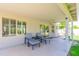 View of the covered patio with two chairs and small table, windows and grass at 3544 E Fox St, Mesa, AZ 85213