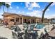 Backyard patio with pool, outdoor kitchen, patio furniture and view of home, palm trees, and blue skies at 3797 N 156Th N Dr, Goodyear, AZ 85395