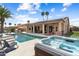 A backyard with a pool, hot tub, covered patio, grill, and desert landscaping at 3797 N 156Th N Dr, Goodyear, AZ 85395