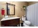 Bathroom featuring a wood vanity, a decorative mirror, and tiled shower at 3797 N 156Th N Dr, Goodyear, AZ 85395