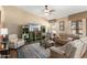 Cozy living room with a comfortable sectional, display shelving, and abundant natural light at 3797 N 156Th N Dr, Goodyear, AZ 85395