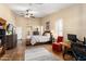 Bright main bedroom with ensuite bath, hardwood floors, a desk area, and a patterned rug at 3797 N 156Th N Dr, Goodyear, AZ 85395