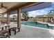 Covered patio overlooking the pool with a waterfall feature and comfortable seating at 3797 N 156Th N Dr, Goodyear, AZ 85395
