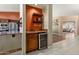 A beautifully designed wet bar with granite countertop, wine refrigerator, and decorative shelving at 3797 N 156Th N Dr, Goodyear, AZ 85395