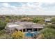 An aerial view showcases a home with a pool, patio, lush desert landscaping, and mountain views at 39847 N 105Th Pl, Scottsdale, AZ 85262
