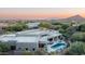 An aerial view showcasing the property's pool, patio seating, desert landscaping, architectural features, and mountain backdrop at 39847 N 105Th Pl, Scottsdale, AZ 85262
