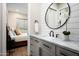 Stylish bathroom with a marble countertop, modern fixtures, and an elegant round mirror at 39847 N 105Th Pl, Scottsdale, AZ 85262