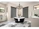Elegant bathroom with freestanding tub, chandelier, and marble tile flooring at 39847 N 105Th Pl, Scottsdale, AZ 85262